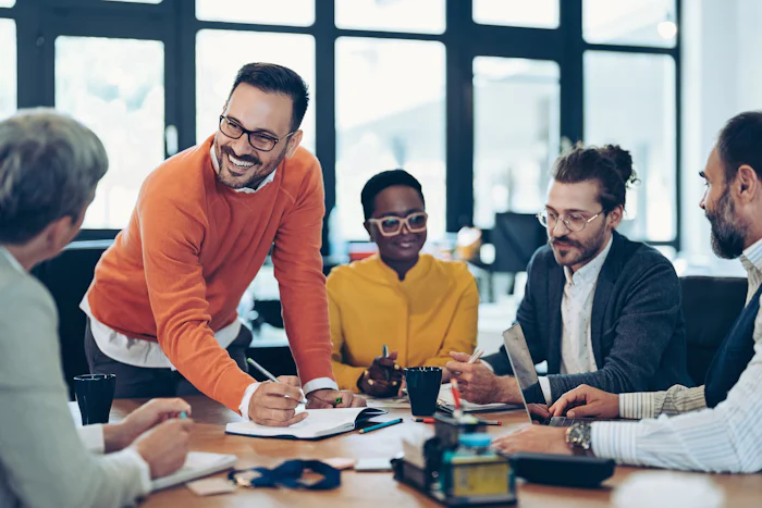 Relaxed, happy leader explaining his concept during a meeting. Multiracial group of business people sitting around a table.