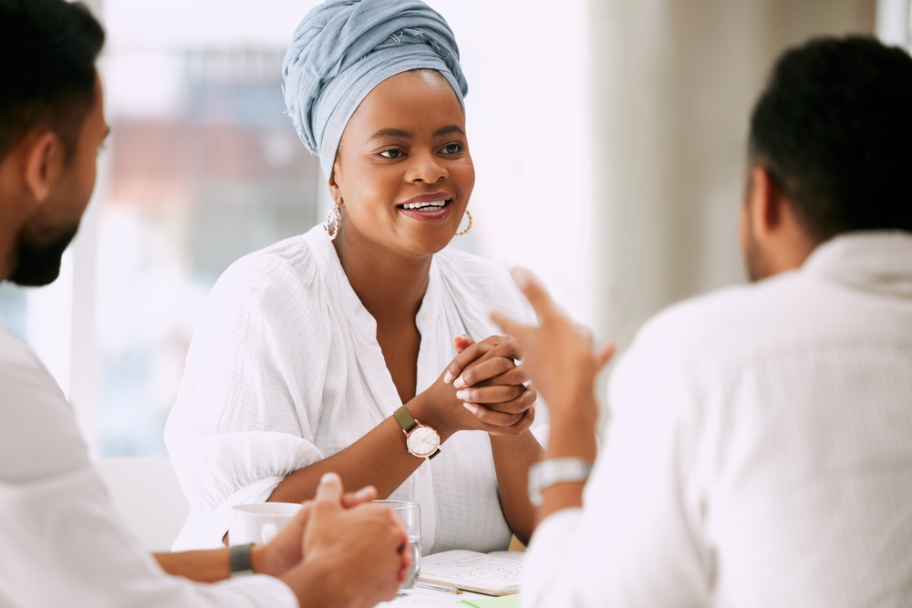 Business woman listening intently to two colleagues
