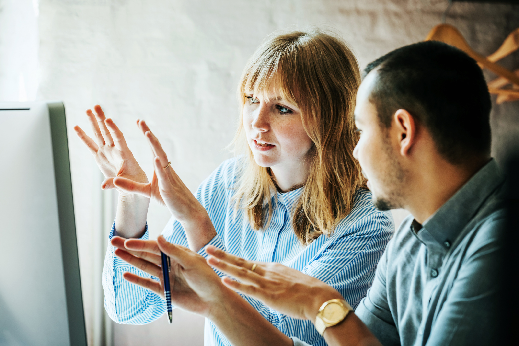 Two business colleagues problem-solving at a computer together in the office.