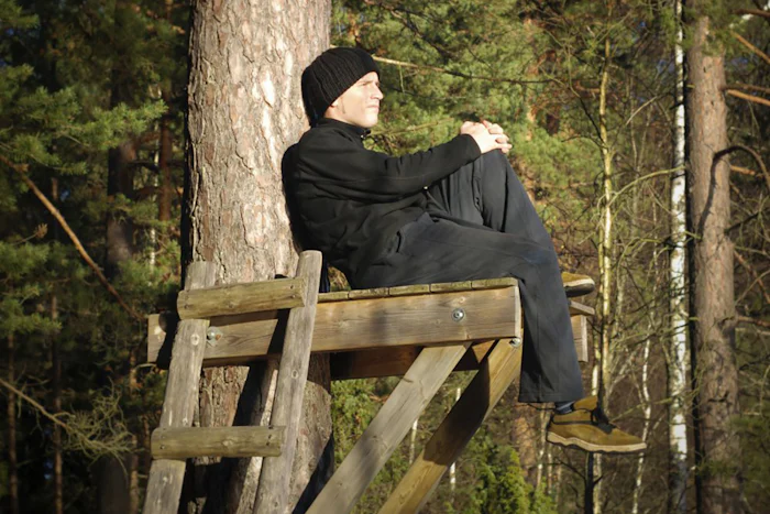A man sits thinking on a platform high up on a tree. decision tree analysis problem solving