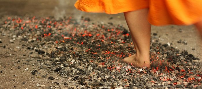 Ground shot of someone walking barefoot on burning coals
