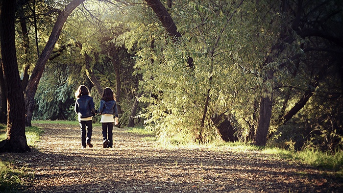 Two girls walking in autumn woods