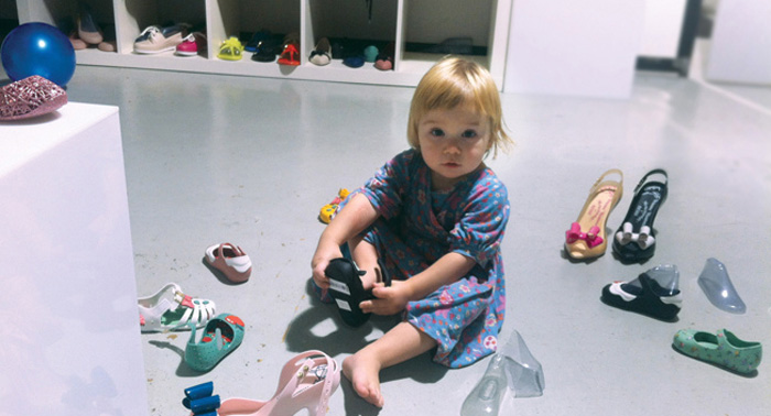A young girl trying on shoes.