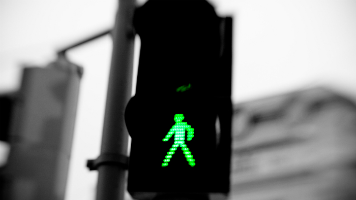 Green person sign on a crosswalk screen