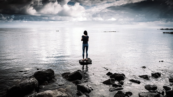 woman standing on rock in water