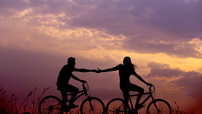 Couple cycling in the sunset