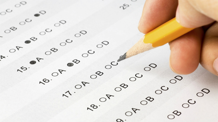 Someone using a pencil to fill out a multiple choice test.