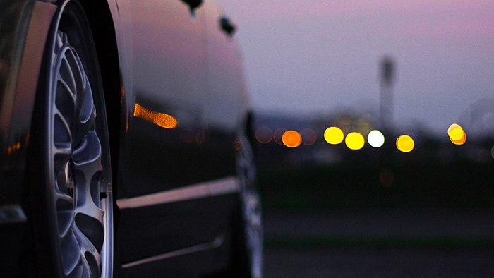 Car hubcaps in evening with distant lights