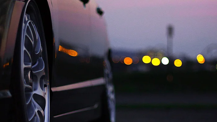 Car hubcaps in evening with distant lights