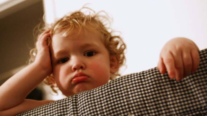 A child leaning on their hand.