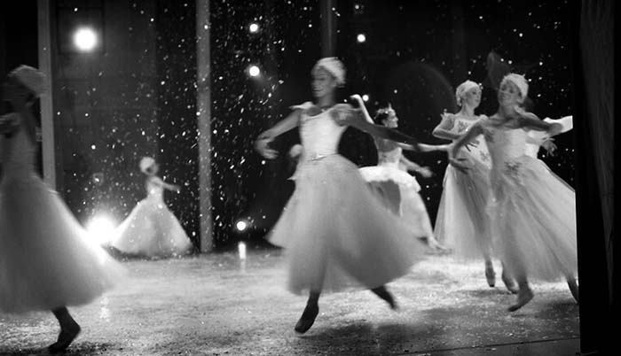 Black and white photo of ballerinas in white long dresses on a stage
