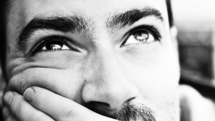 A man sitting looking up, thinking.